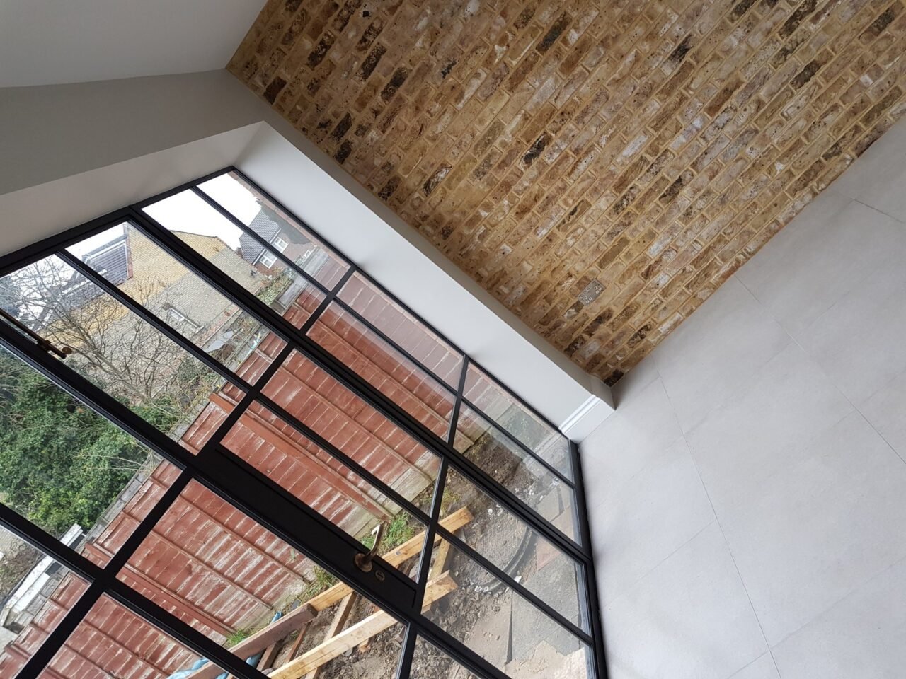 Crittall glazed gable and exposed brick in a rear extension in Chingford by Brick By Brick
