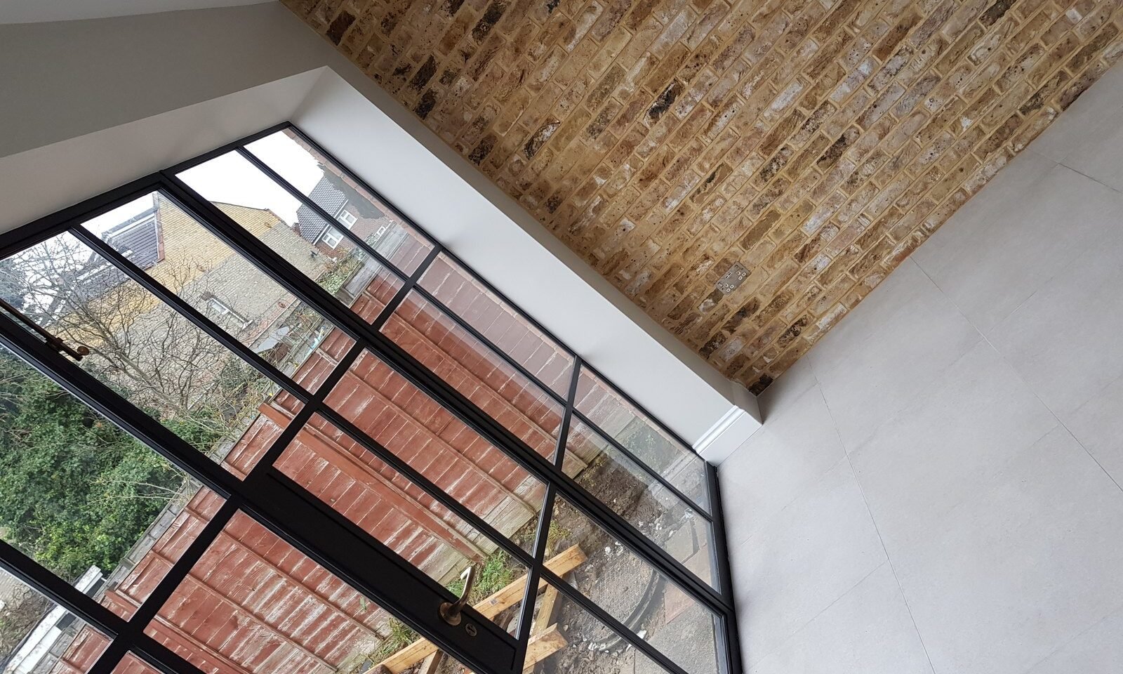 Crittall glazed gable and exposed brick in a rear extension in Chingford by Brick By Brick